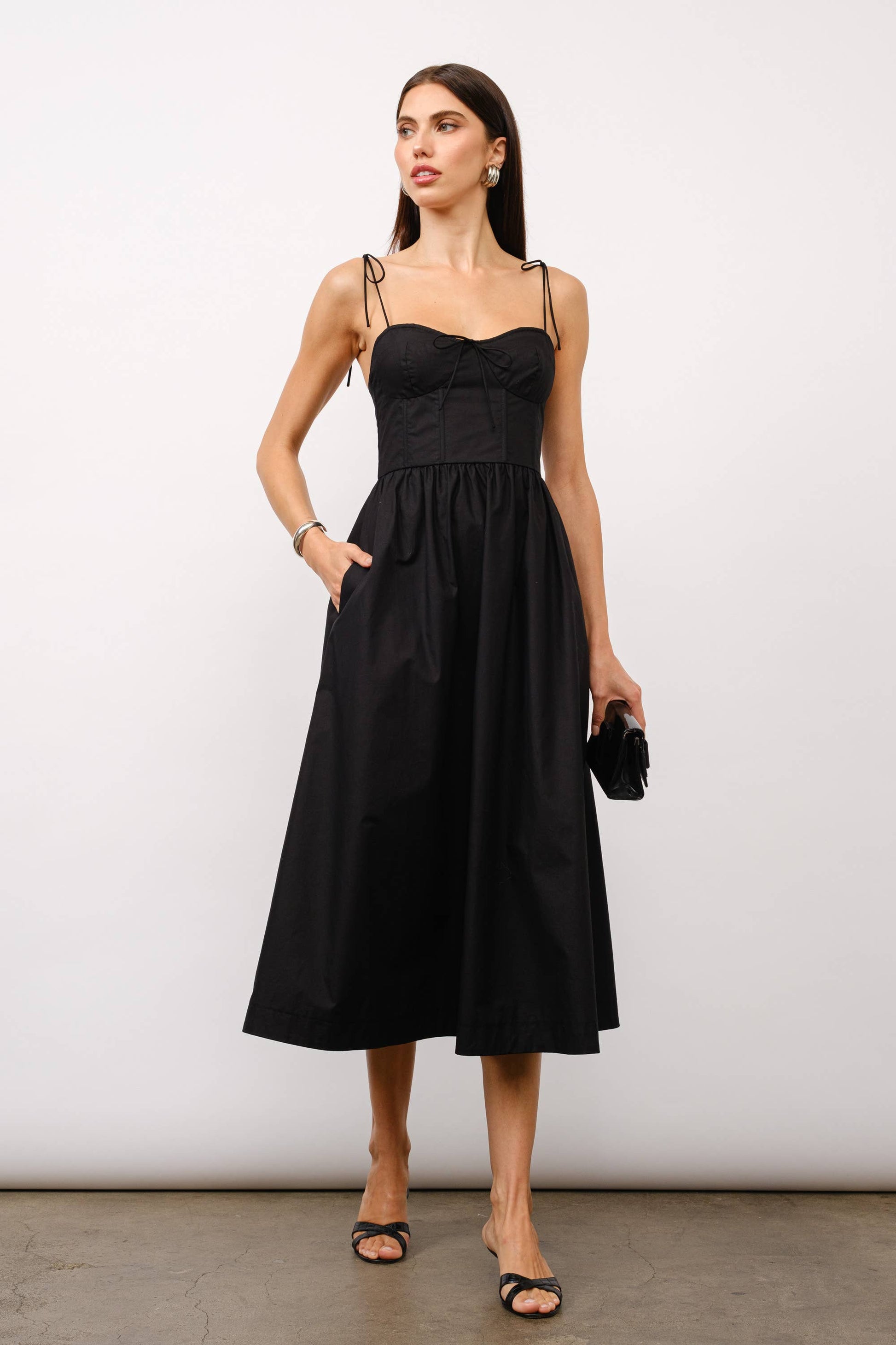 Black midi dress, corset midi dress, tie-strap dress, sweetheart neckline dress, black dress for date night, cocktail party dress, summer wedding outfit, corset dress with boning, elegant black dress, versatile midi dress, dress with pockets, fashion boutique dress.